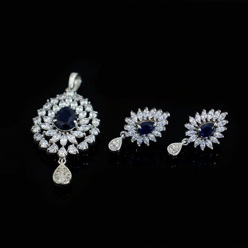Jewelry set with pendant and earrings featuring blue stones on a dark background