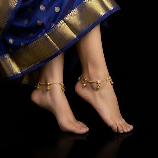Gold necklace with dangling beads on a dark background, featuring the brand 'SAHELI'.