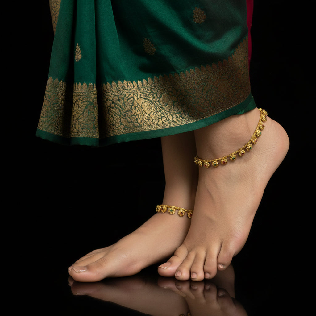 Gold necklace with green and red stones on a black background