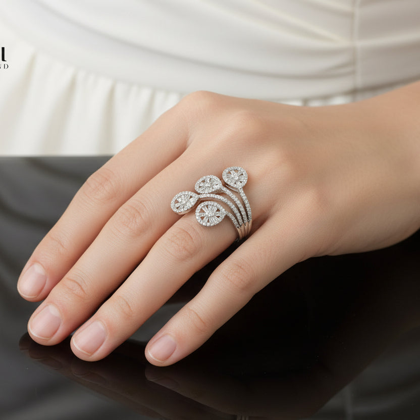 Silver floral ring on a black hand with 'SAHELI' branding.