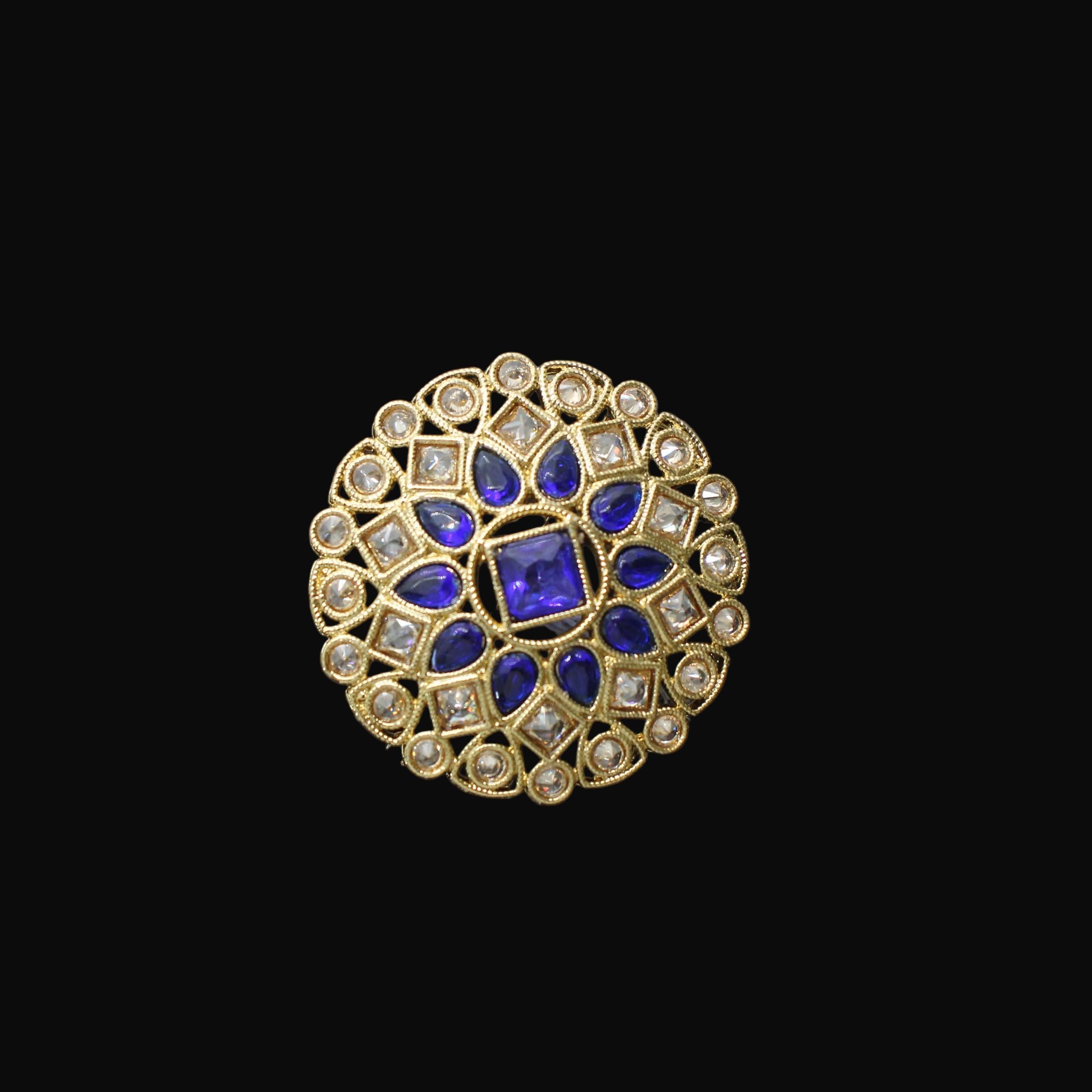 Gold ring with blue gemstones on a black mannequin hand against a gray background