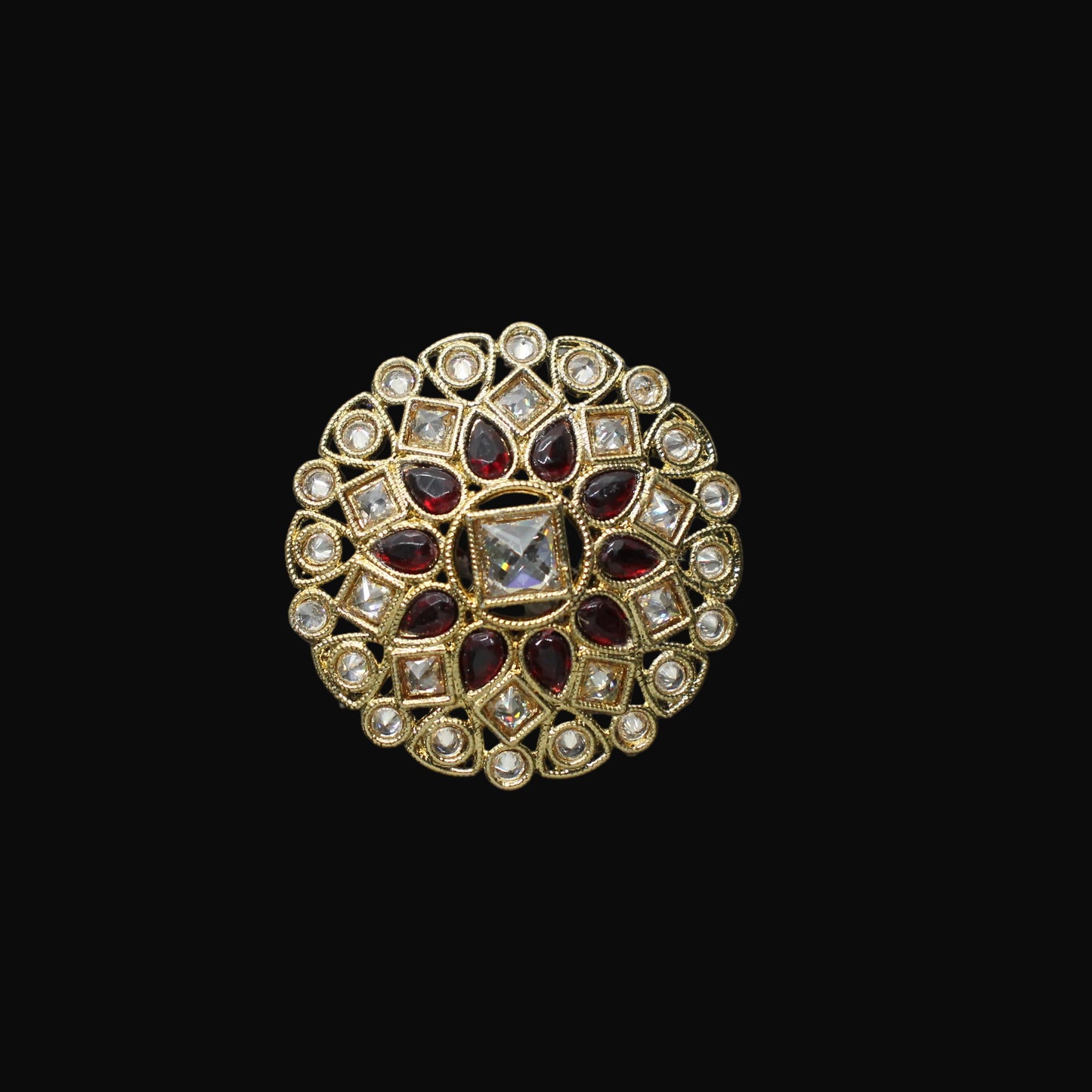 Decorative ring with gemstones on a black mannequin hand against a dark background