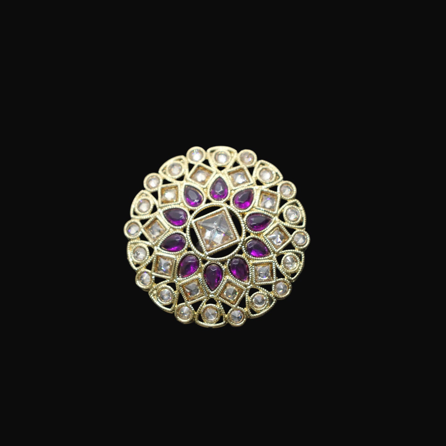 Decorative ring with purple gemstones on a black mannequin hand against a dark background