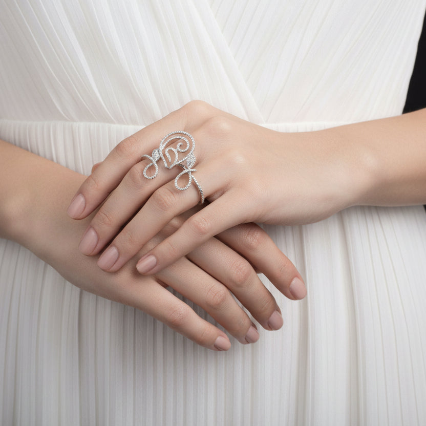 Silver ring with intricate design on a black background