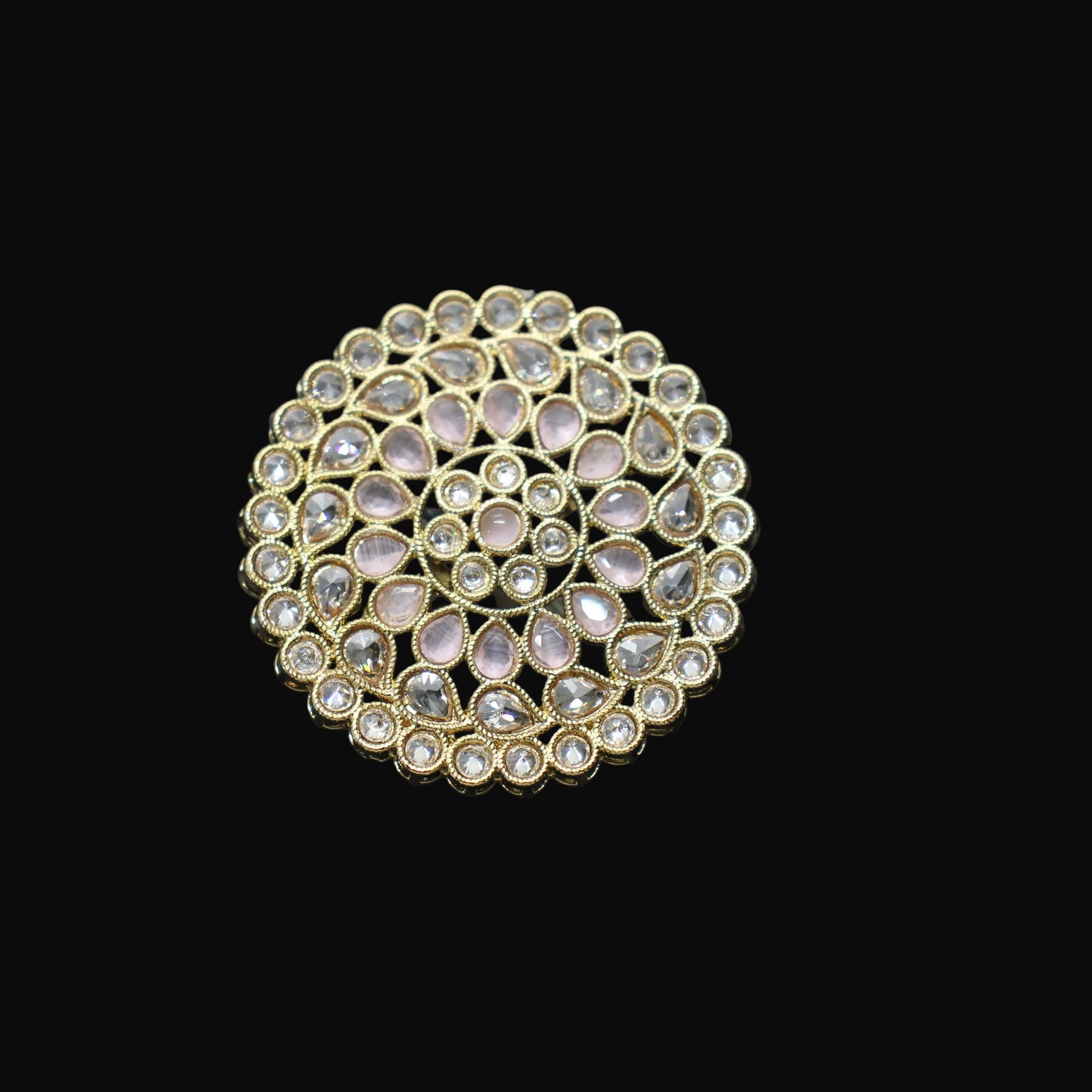 Gold ring with gemstones on a black mannequin hand against a dark background