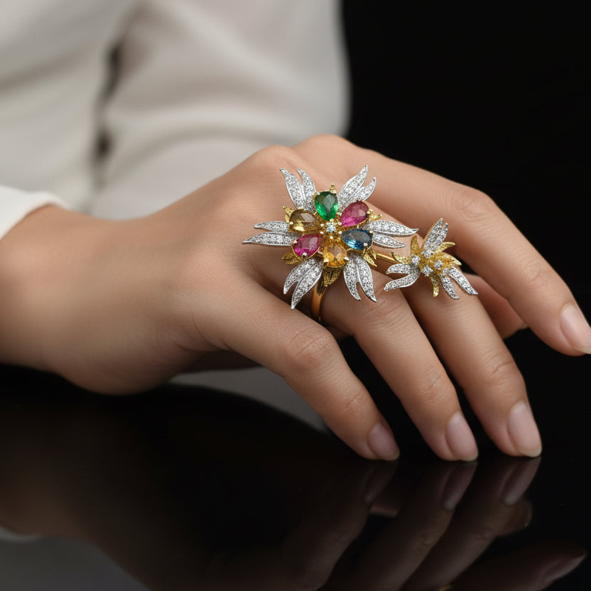 Gold and silver earrings with gemstones on a gray background, featuring the brand 'SAHELI'.
