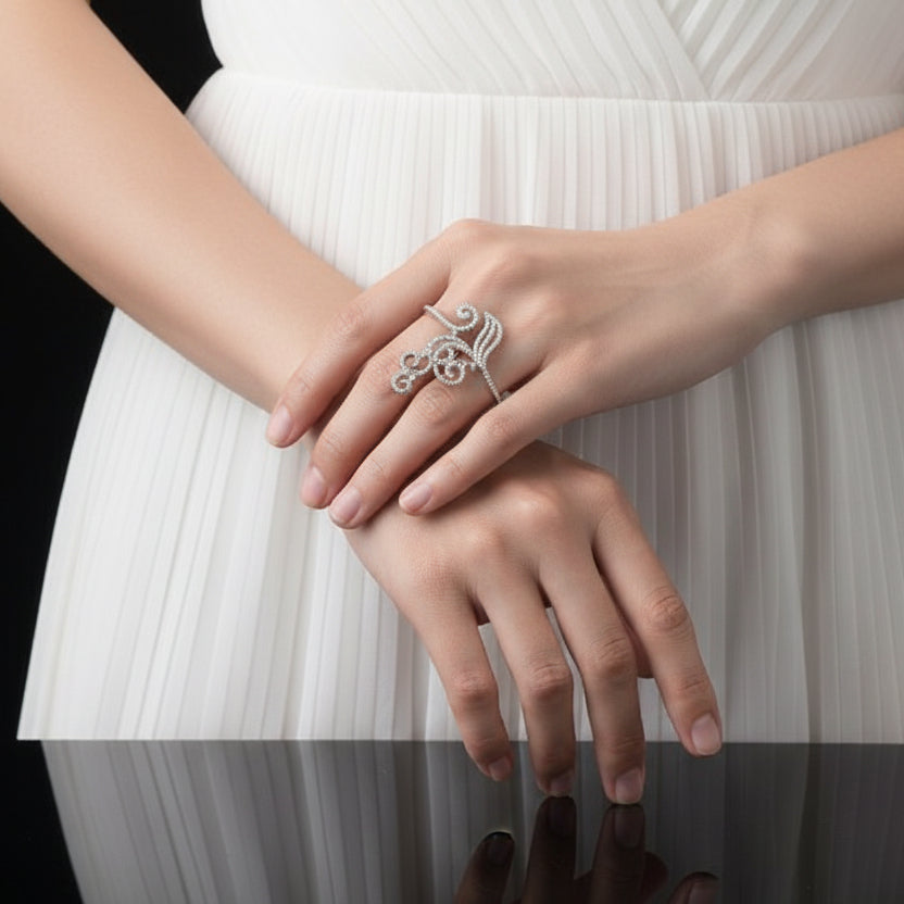 Silver ring with intricate design on a black background