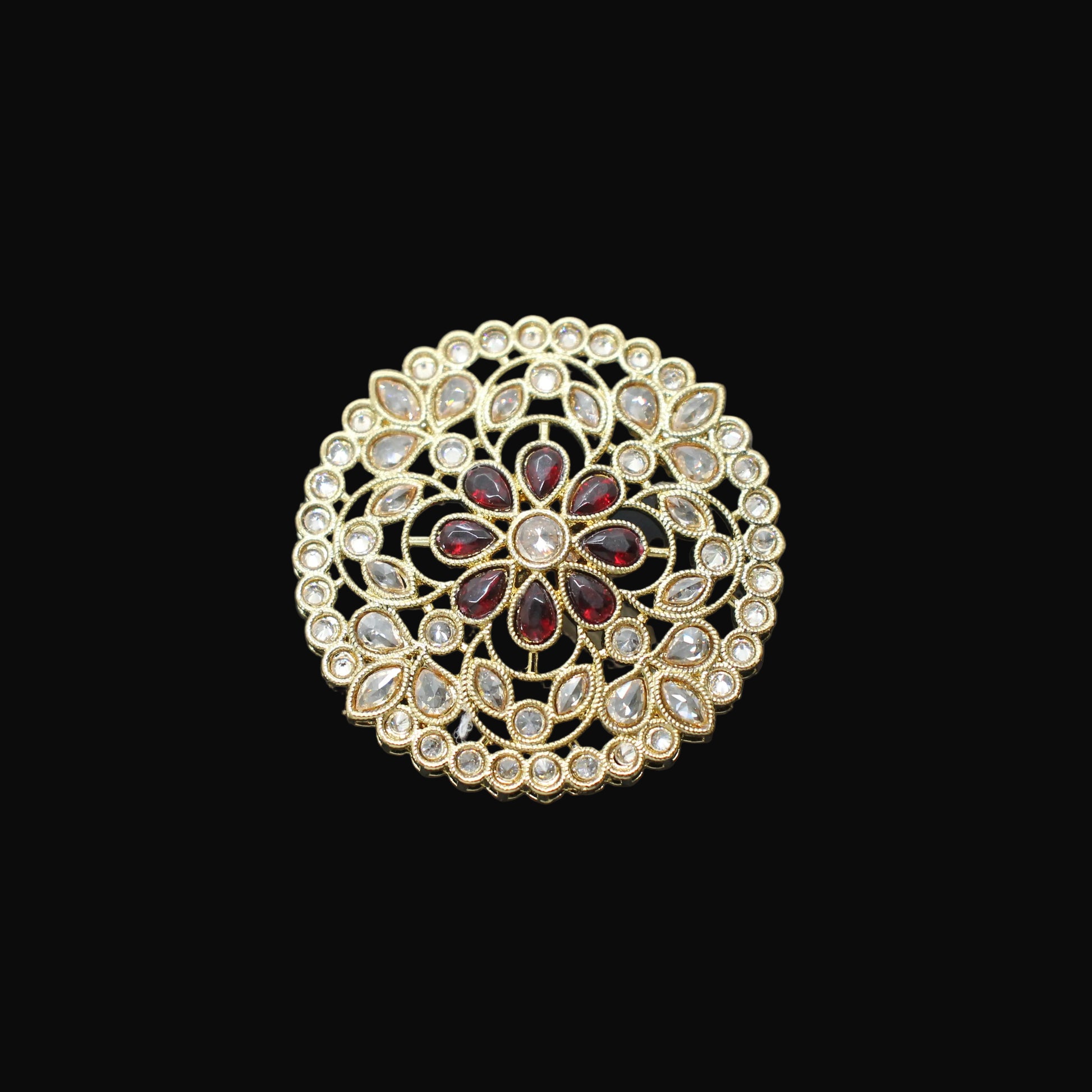 Gold and red gemstone ring on a black mannequin hand against a gray background