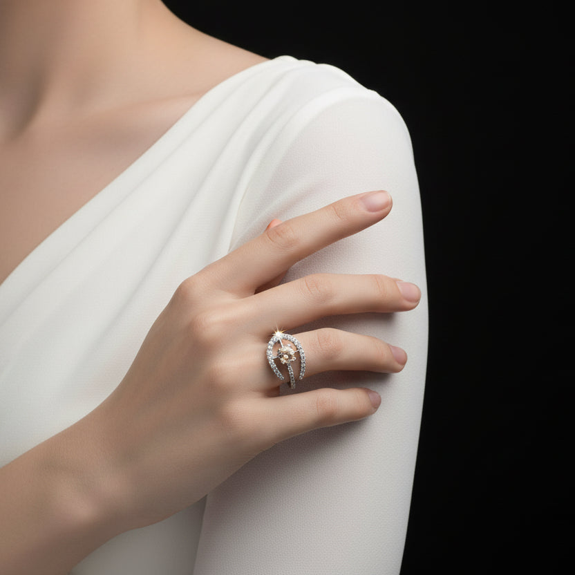 Silver ring with a central gemstone on a dark surface, branded 'Saheli'.