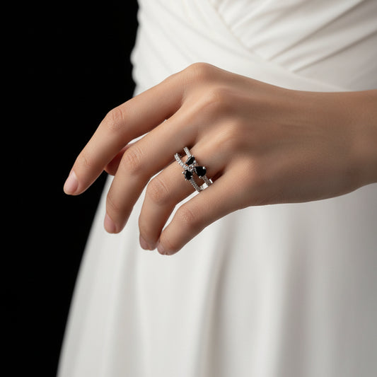 Silver ring with intricate design on a gray background, featuring the brand 'SAHELI'.