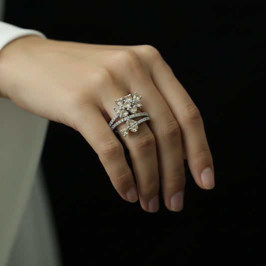 Silver ring with gemstones on a black background, featuring the 'Saheli' brand.