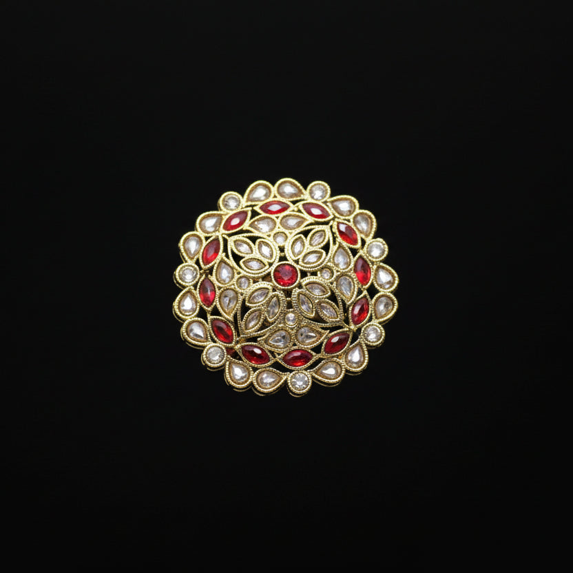 Decorative ring with red gemstones on a black mannequin hand against a dark background