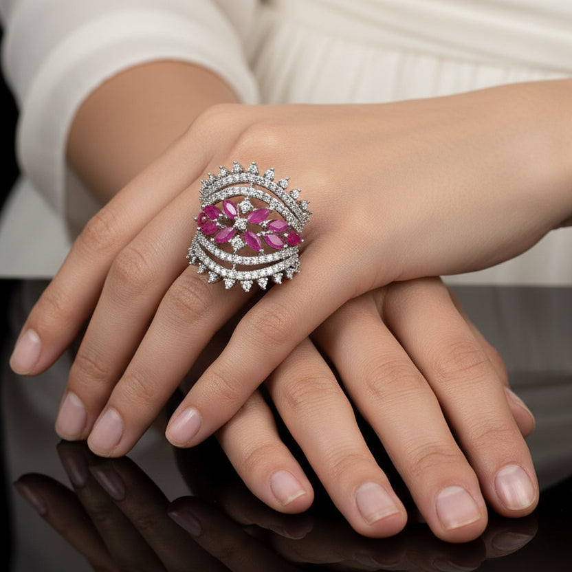 Silver ring with pink gemstones on a gray background, featuring the brand 'SAHELI'.