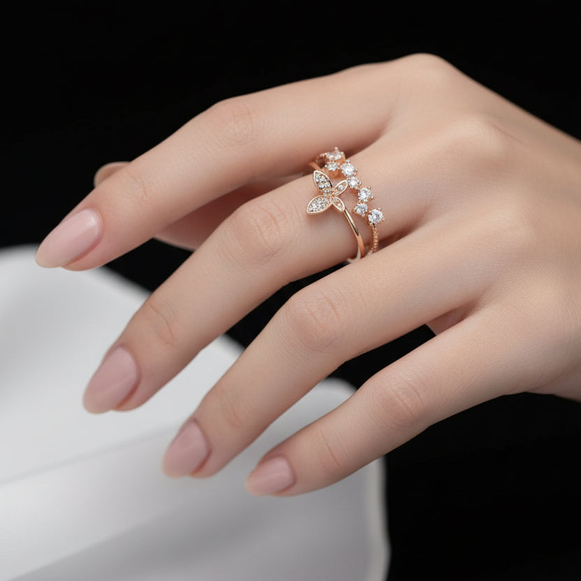 Gold ring with floral design on a black mannequin hand against a gray background