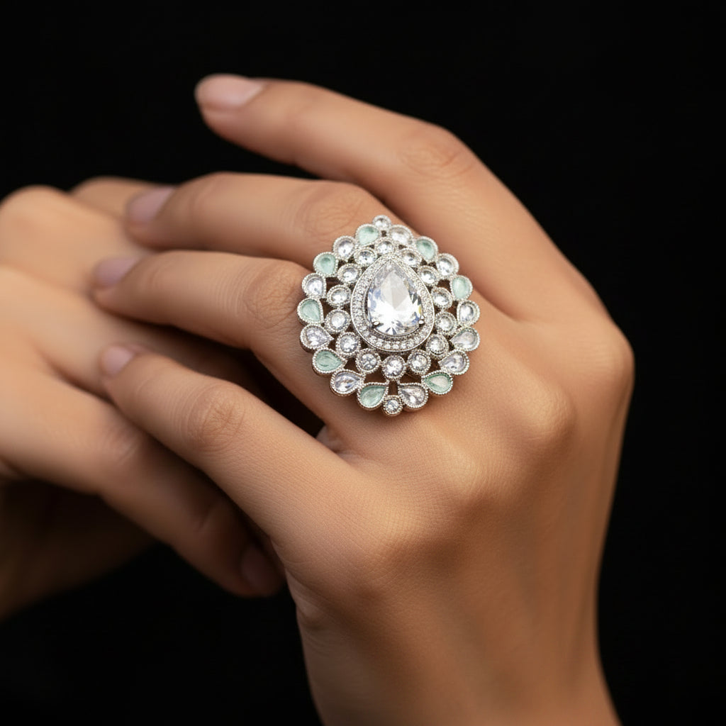 A large ornate silver-toned ring with a skull-shaped center stone and surrounding clear stones, displayed on a black gloved hand against a black background. The brand name SAHeli My Best Friend is printed above the hand.