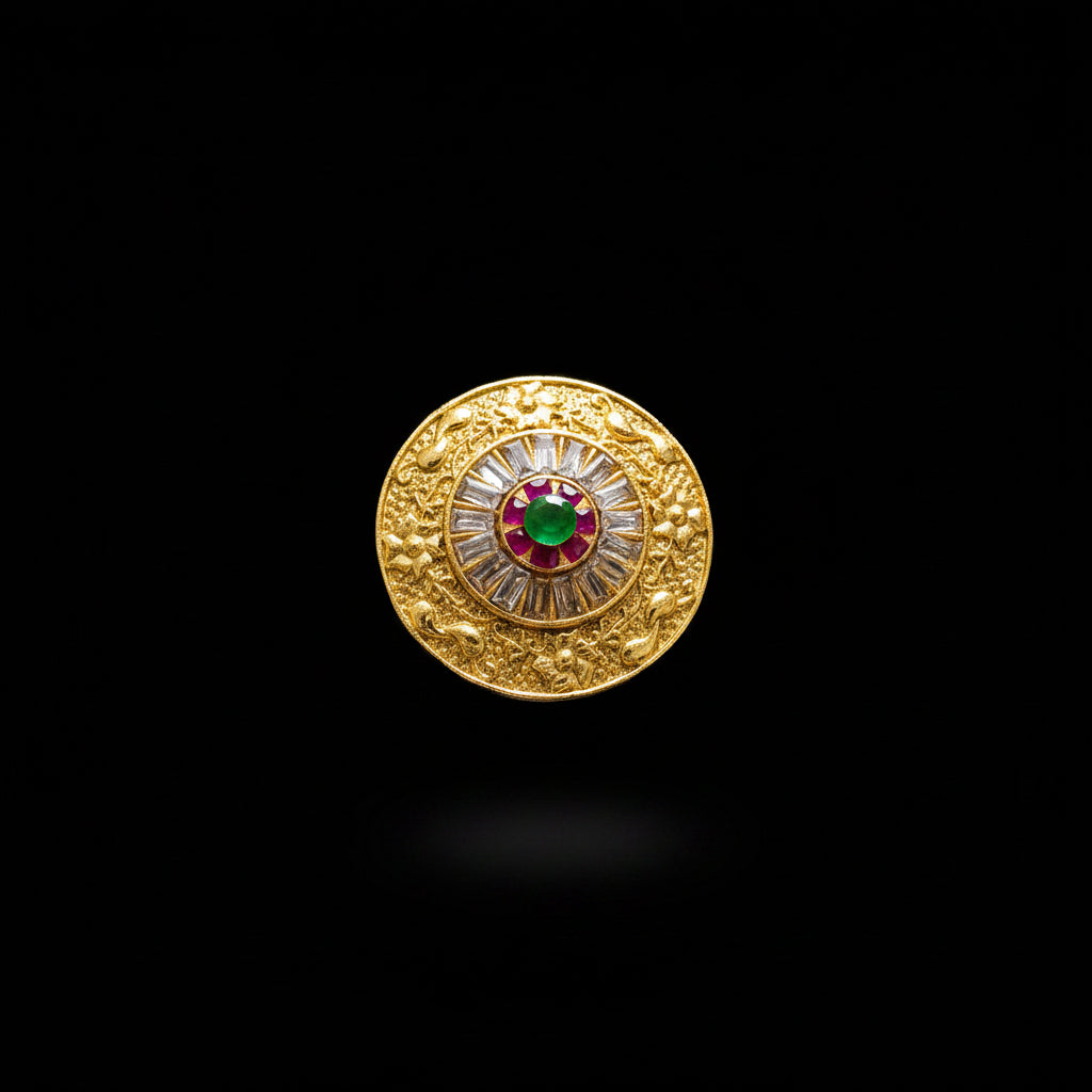 A large gold-toned statement ring displayed on a black mannequin hand. The ring features an intricate circular design with a central red and green motif surrounded by clear stones, set against a dark gray background with a 'SAHELL' watermark in the top left corner.