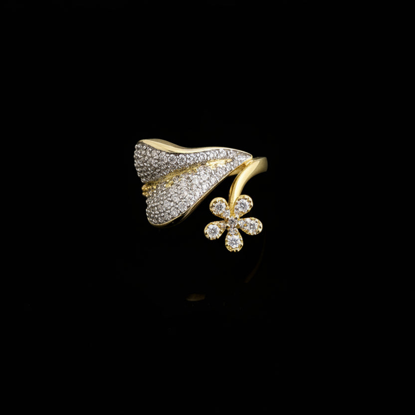 Gold ring with floral design on a gray background, featuring the brand 'Saheli'.