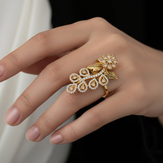 Gold brooch on a black hand with 'Saheli' branding.