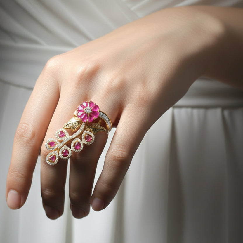 Gold ring with pink gemstones on a black mannequin hand, branded 'Saheli'.