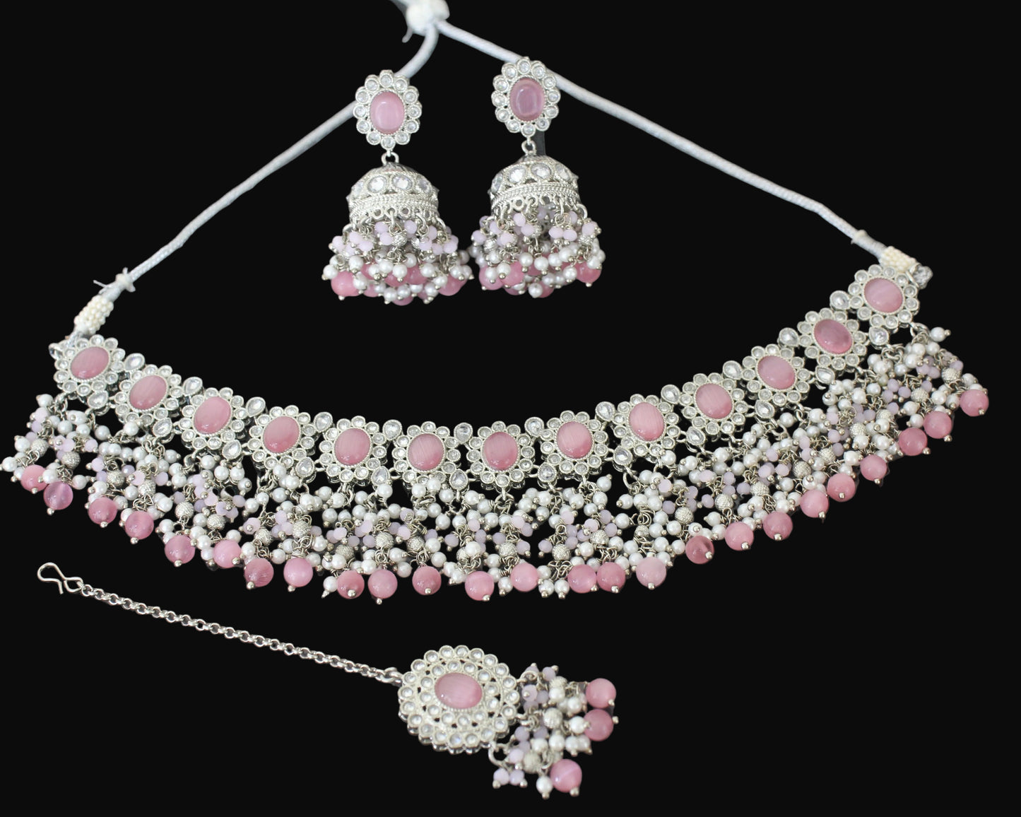 Jewelry set with necklace, earrings, and ring on a dark background