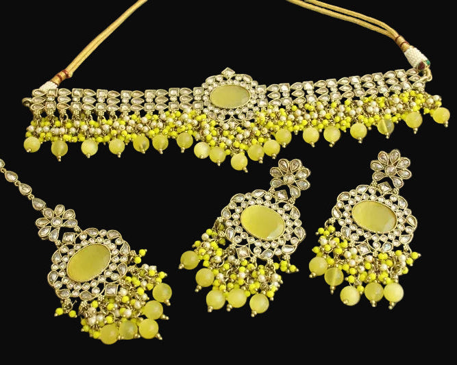 Jewelry set with yellow stones and gold accents on a dark background