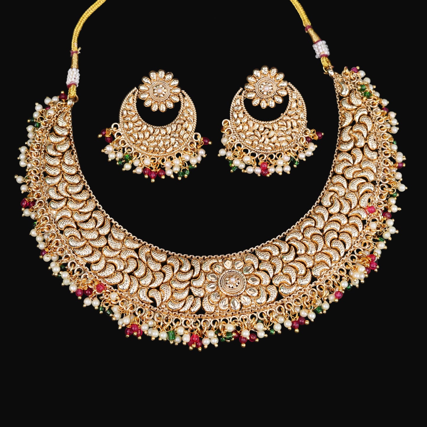 Gold necklace and earrings set with 'Saheli' branding on a dark background