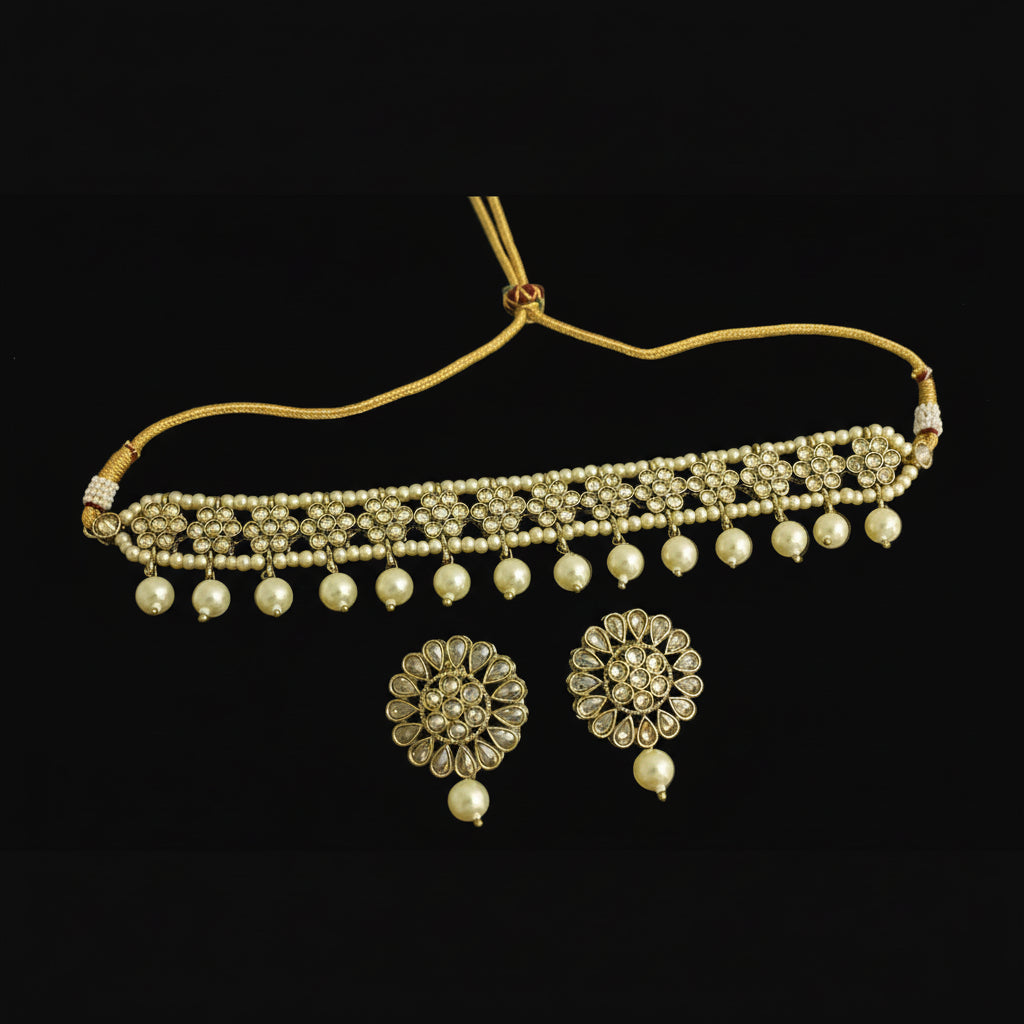 Gold necklace with pearl drops and matching earrings on a dark background
