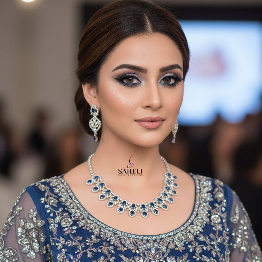 Jewelry set with necklace and earrings featuring blue stones on a dark background, branded 'Saheli'.