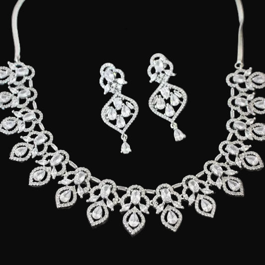 Jewelry set with necklace and earrings on a dark background, featuring the brand 'Saheli'.