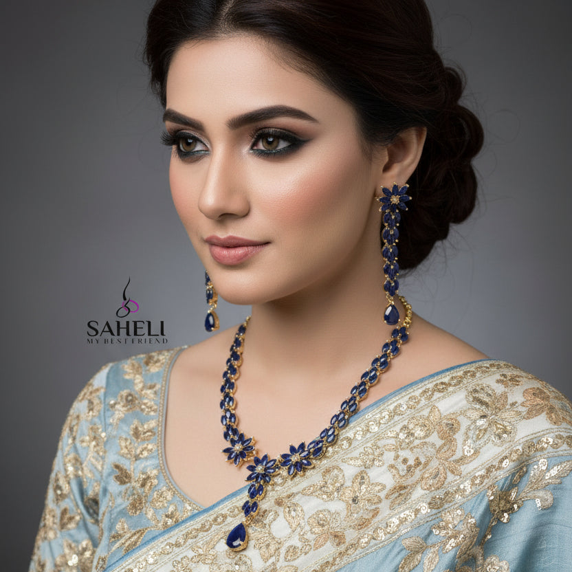 Jewelry set with necklace and earrings on a gray background, featuring the brand 'SAHELI'.