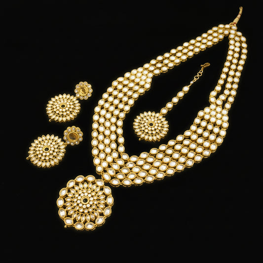 Gold necklace and earrings set with 'Saheli' branding on a dark background