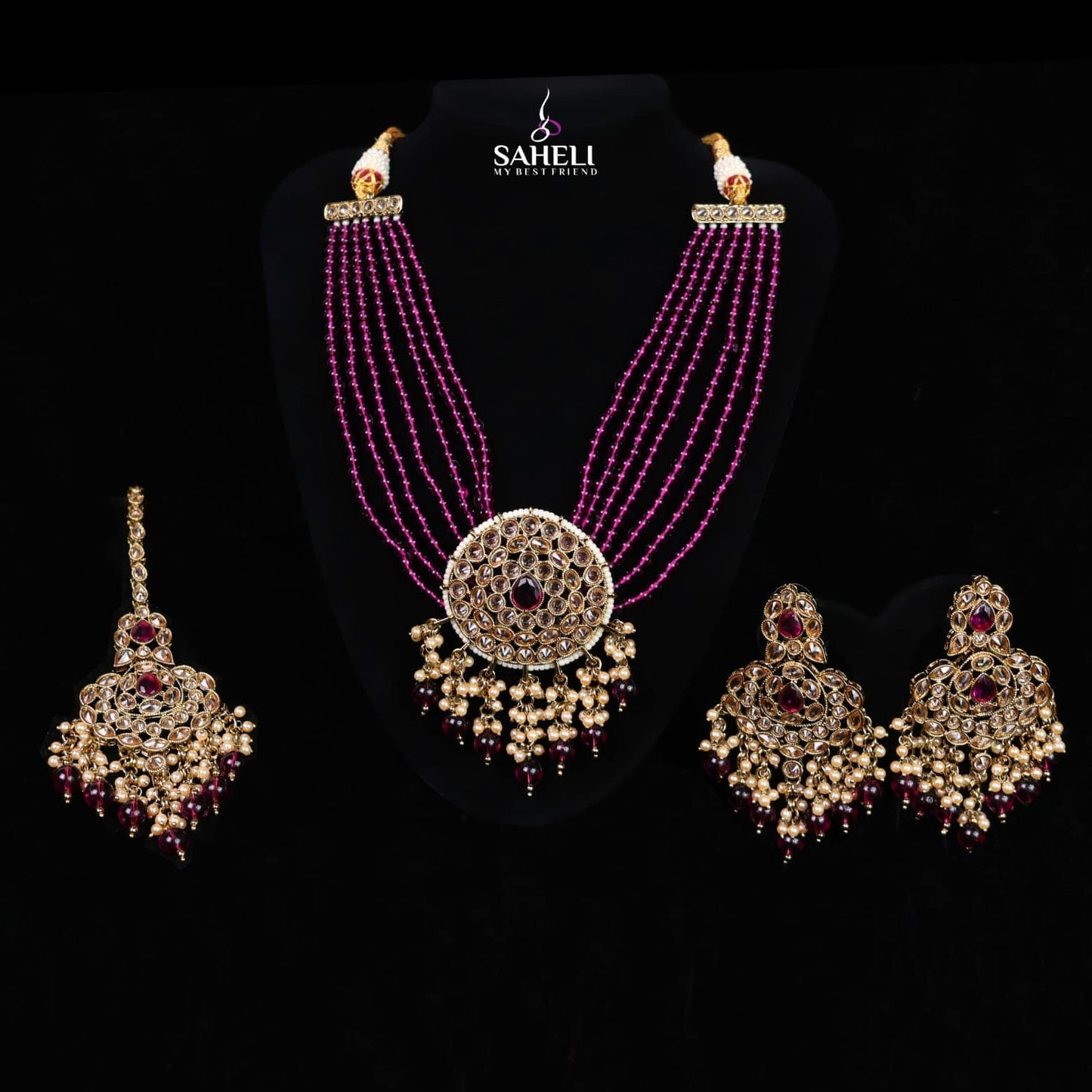 Jewelry set with necklace and earrings on a black background, featuring the brand 'Saheli'.