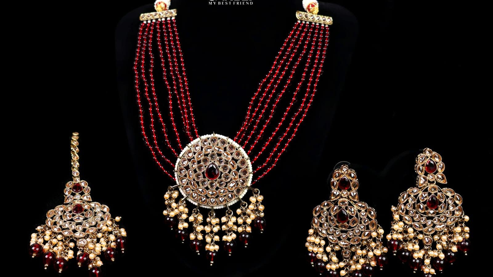 Jewelry set with necklace and earrings on a black background, featuring the brand 'Saheli'.