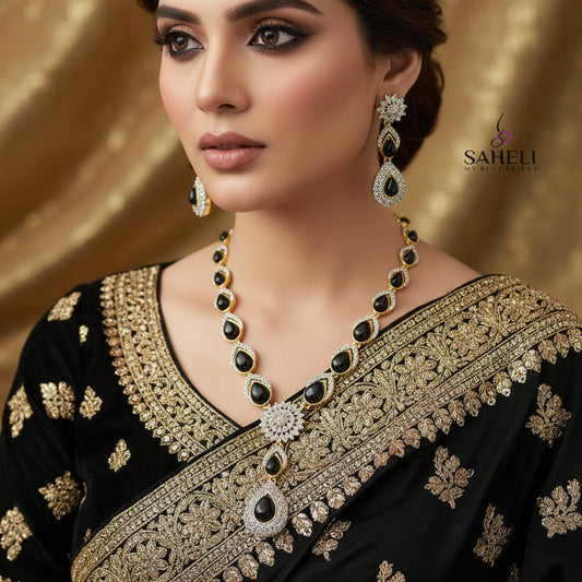 Jewelry set with necklace and earrings on a dark background, featuring the brand 'Saheli'.