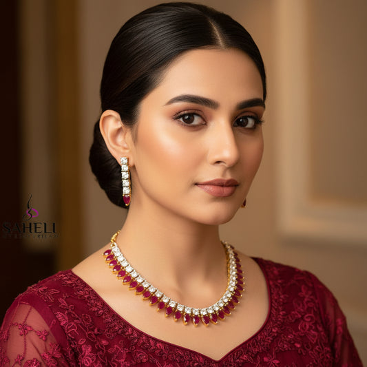 Jewelry set with necklace and earrings on a gray background, featuring the brand 'Saheli'.