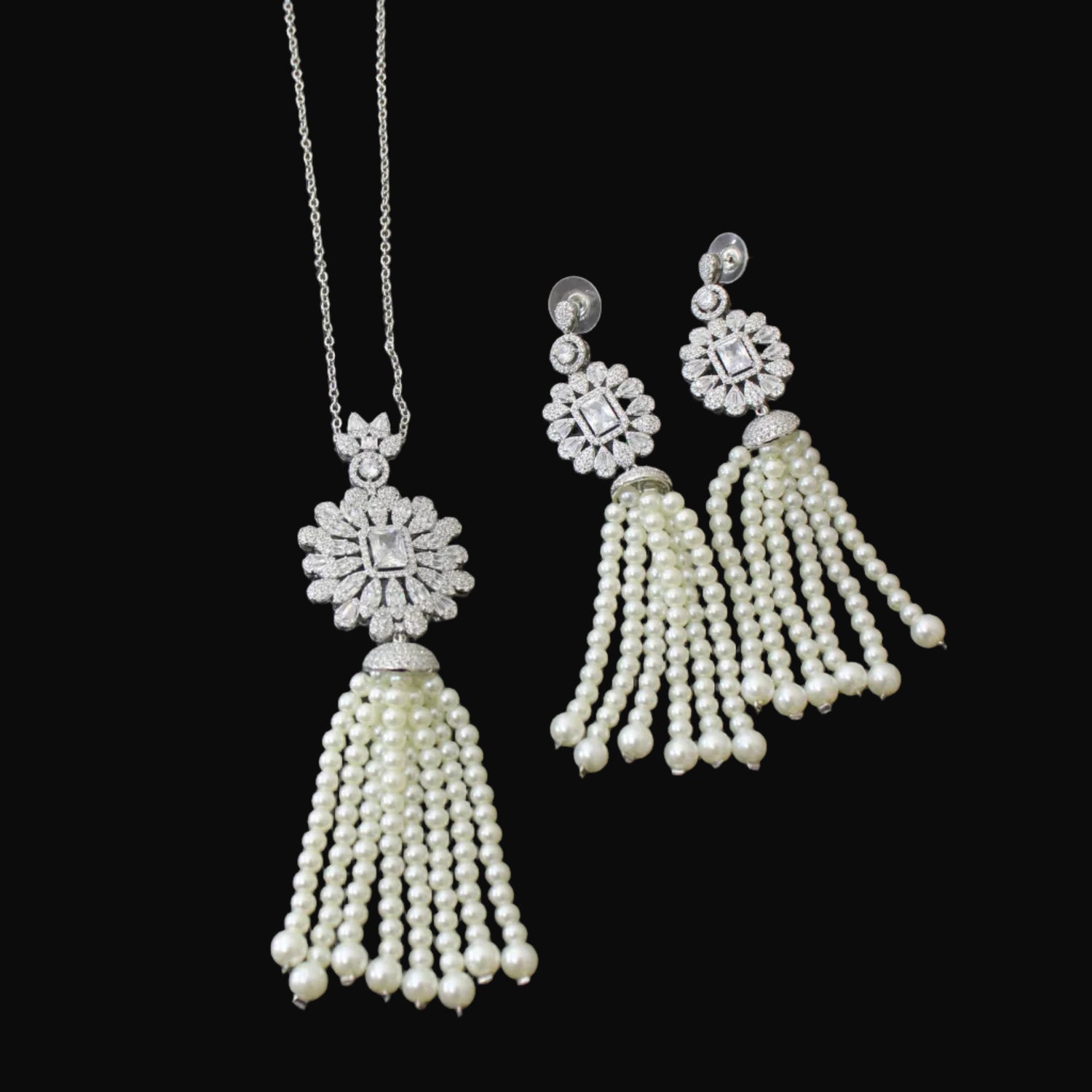 Pearl tassel necklace and earrings on a reflective surface