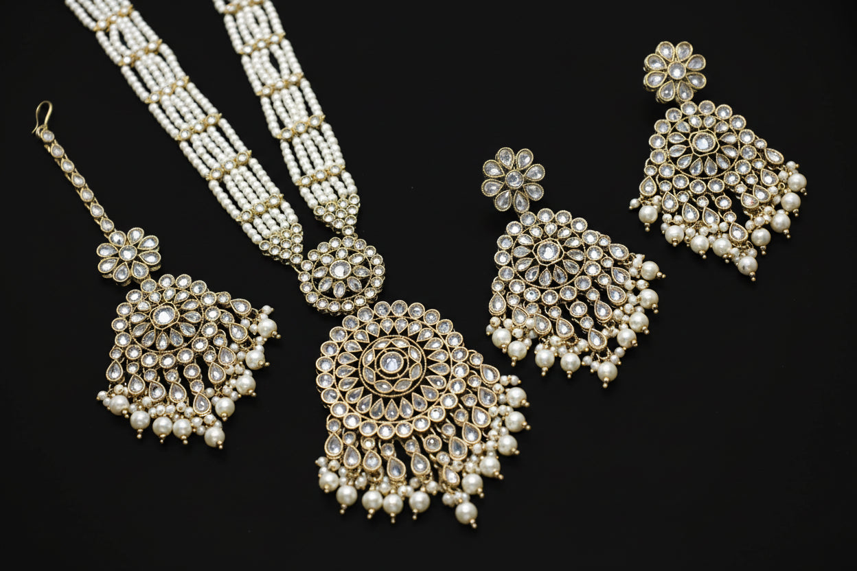 Pearl jewelry set including necklace, earrings, and bracelet on a dark background