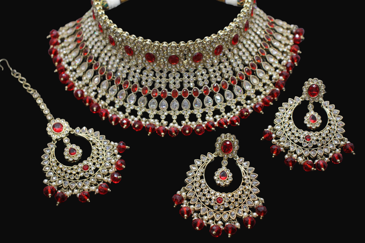 Ornate jewelry set with red stones on a dark background