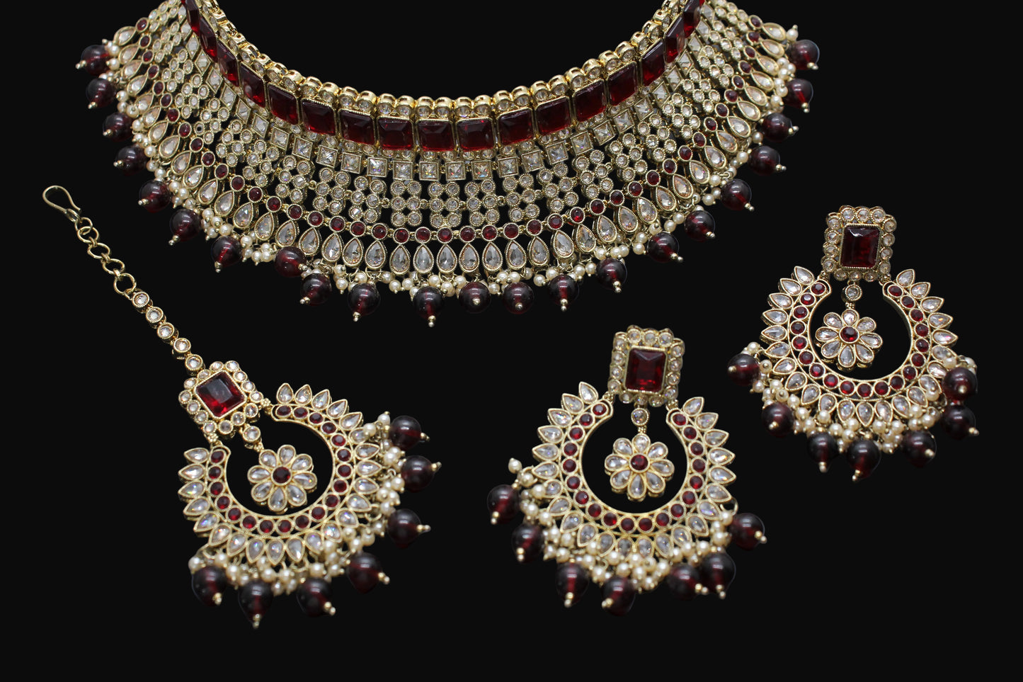 Ornate jewelry set with necklace, earrings, and hair accessories on a dark background