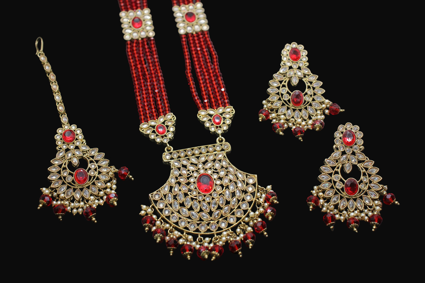 Set of gold and red jewelry on a dark background