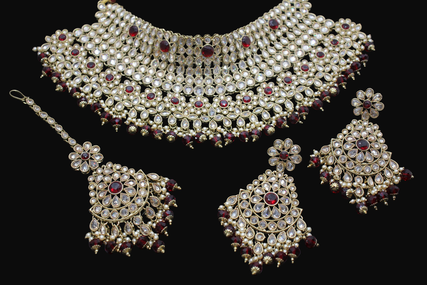 Ornate jewelry set with necklace, earrings, and bangles on a dark background
