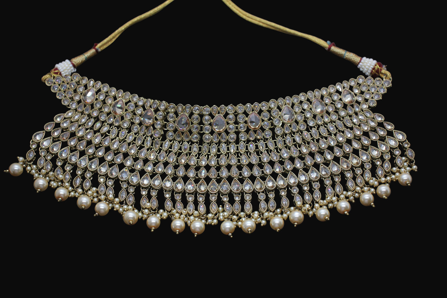 Ornate necklace with pearls and gemstones on a dark background