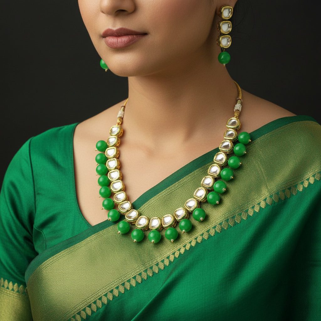 Green and gold necklace and earrings set on a black background with 'SAHELI' branding.