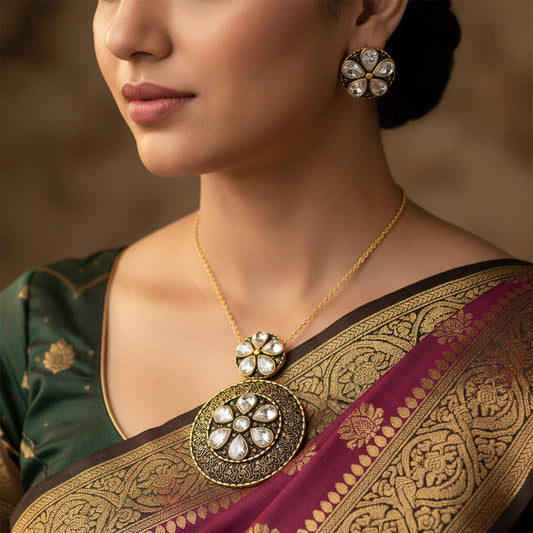 Ornate gold and black earrings with clear stones on a dark background, featuring the brand 'Saheli'.
