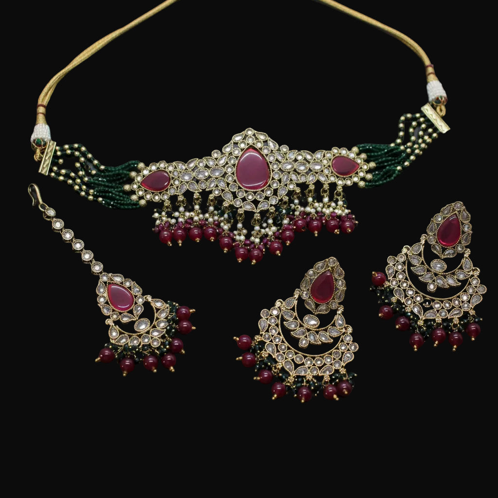 Ornate jewelry set with red stones on a dark background