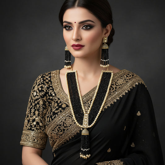 A traditional Indian jewelry set featuring a long beaded necklace and matching earrings. The necklace has multiple strands of black beads accented with cream-colored pearl-like beads and gold-toned metal details, ending in dangling tassel-like clusters of black and cream beads.