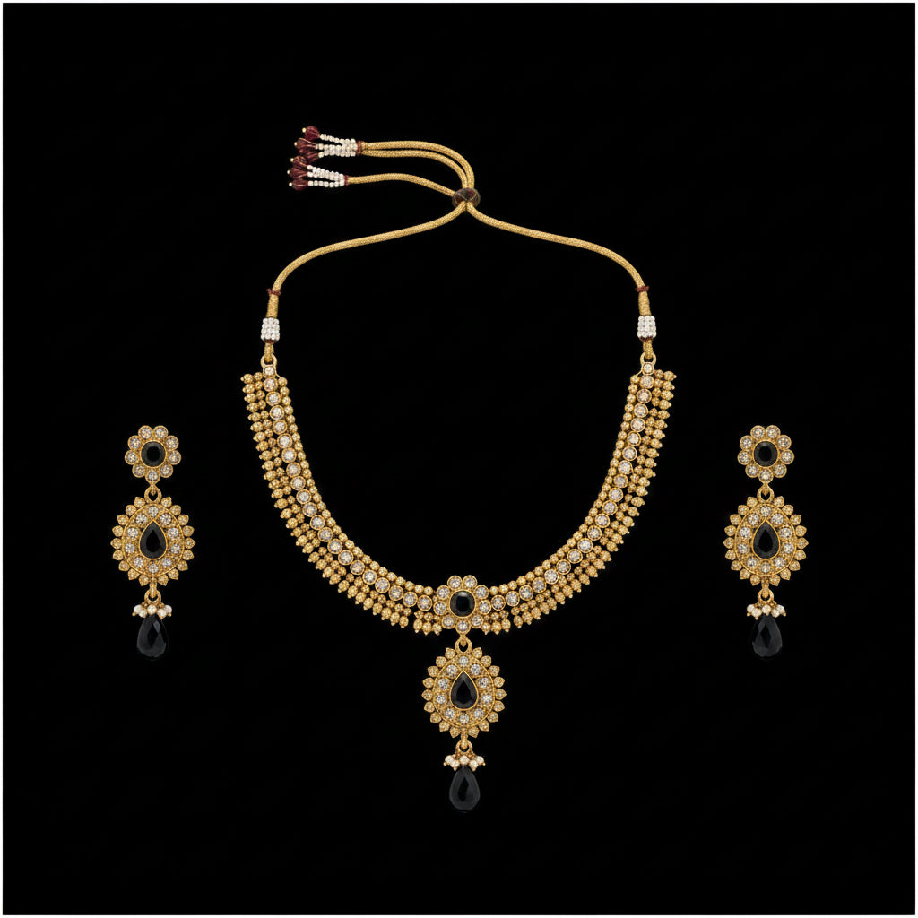 Gold-toned traditional Indian jewelry set featuring a multi-strand necklace, matching drop earrings, and floral earrings with black teardrop beads and white stones, displayed on a dark reflective surface with the brand name 'SAHELL MY BEST FRIEND' printed in the background.