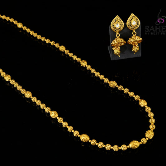 Gold necklace and earrings set with 'Saheli' branding on a gray background