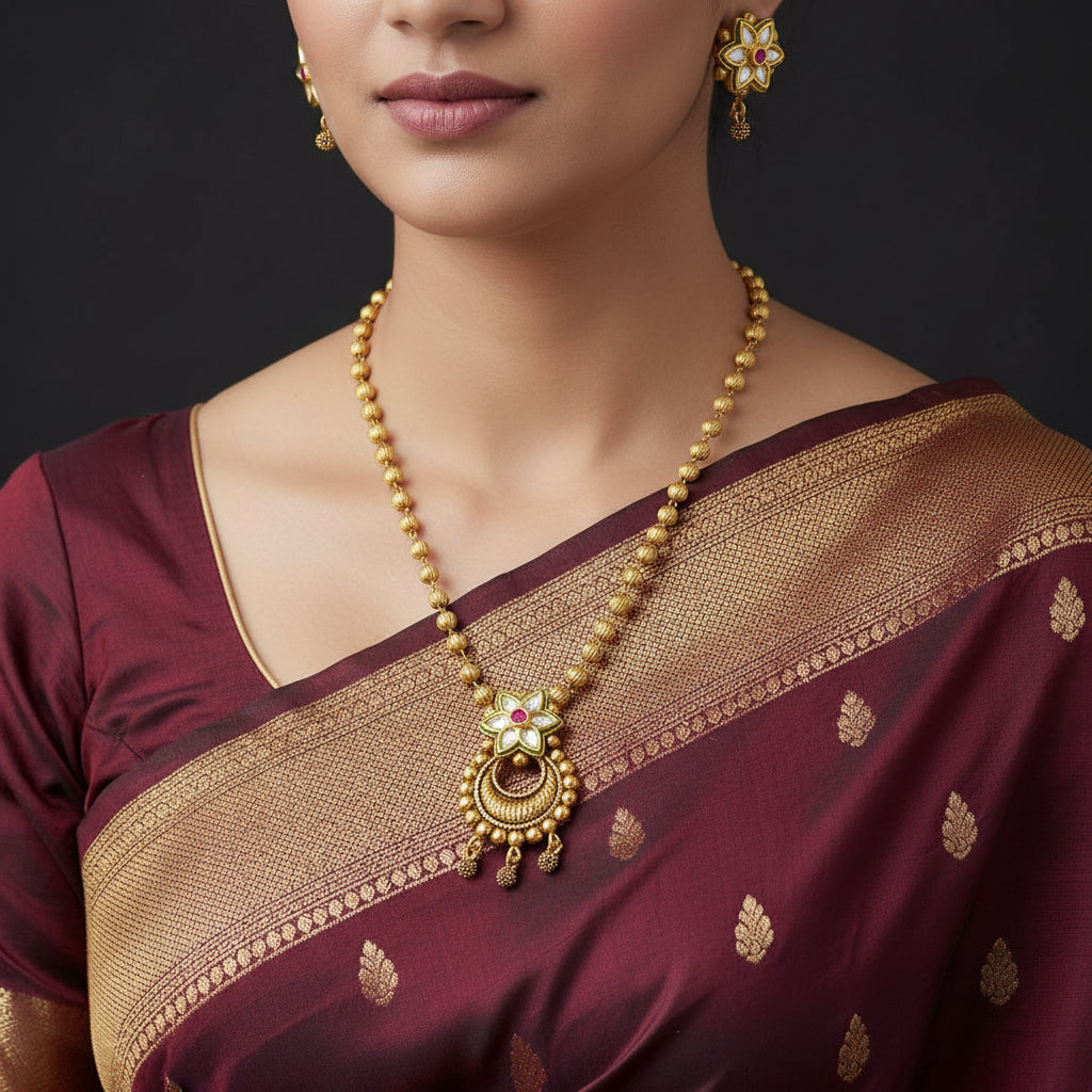 Gold necklace and earrings with floral designs on a dark background, featuring the brand 'Saheli'.