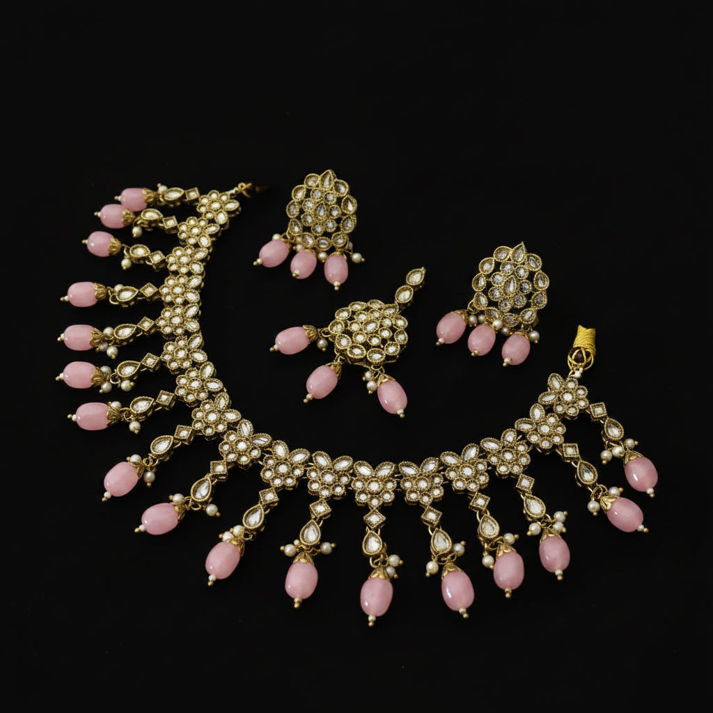 Gold-plated Kundan necklace and matching earrings with green stone accents, displayed on a dark reflective surface. The brand logo 'SAHELI MY BEST FRIEINDS' is visible in the top left, and a small white tag is attached to the necklace.